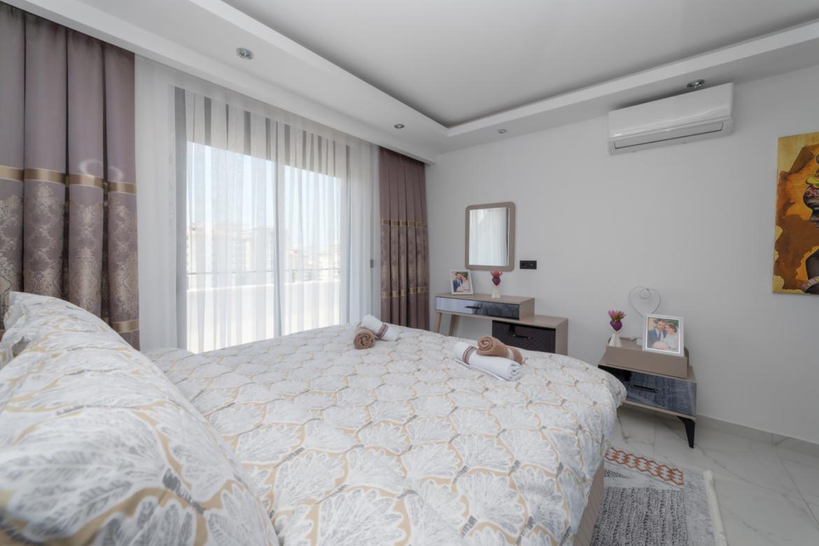 Master bedroom with balcony access in a modern apartment in Mahmutlar